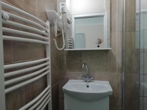 a bathroom with a sink and a mirror at Árpád-ház Apartmanok in Gyula