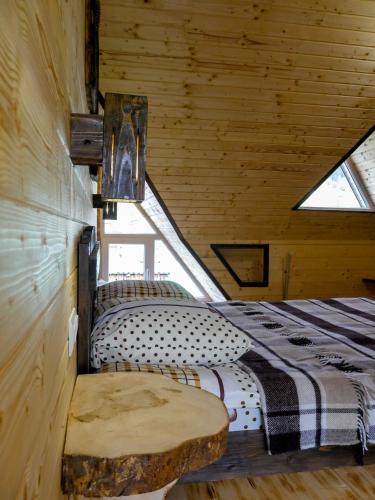 a bedroom in a wooden cabin with a bed and a bench at "Файна хата" in Synevyrsʼka Polyana