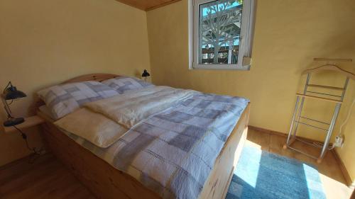 a bedroom with a bed with a window and a ladder at Ferienshaus Zur Lehns mit Garten am Harz in Ilsenburg