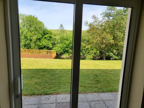 a view of a yard through a sliding glass door at Ardilaun Guesthouse Self Catering in Ennis