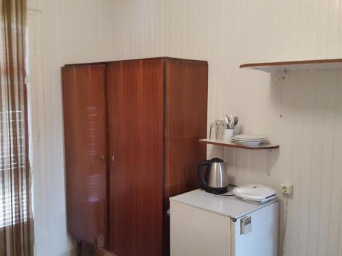 a kitchen with a wooden cabinet next to a refrigerator at faliraki apartments in Benitses
