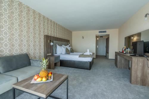 a hotel room with a bed and a table with a bowl of fruit at Katalina SPA Resort in Tsigov Chark