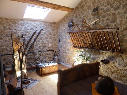 - un salon avec des murs en pierre et un canapé dans l'établissement HAVRE DE PAIX EN GATINE La Tessonniére, à Pougne-Hérisson