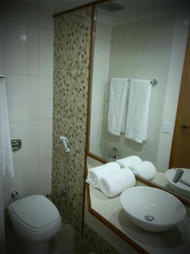 a bathroom with a toilet and a sink and a shower at Setiba Pousada Park in Guarapari