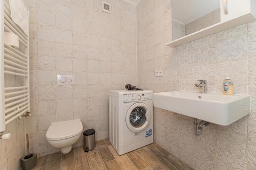 y baño con lavadora y lavamanos. en Coresi modern apartment, en Brasov