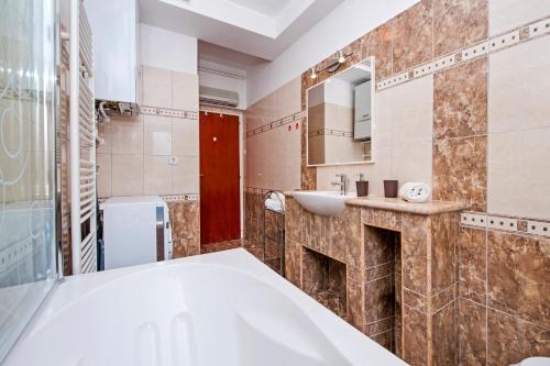 un baño con bañera y lavabo en Apartman Klara, en Rovinj