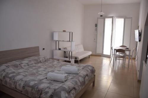 a bedroom with a large bed and a living room at la casa di Marco in Canosa di Puglia