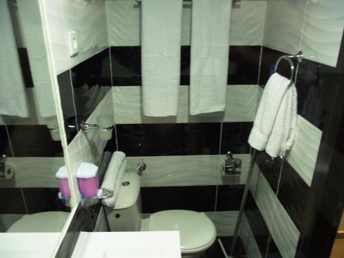 a bathroom with a toilet and a sink and towels at City Apartments in Eilat