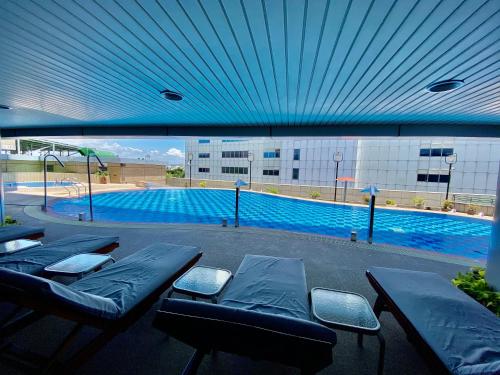 a swimming pool with blue ceilings and benches in front of a building at Evergreen Plaza Hotel - Tainan in Tainan