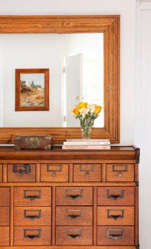 a dresser with a mirror and a vase of flowers on it at The Grand Marigold in McGregor
