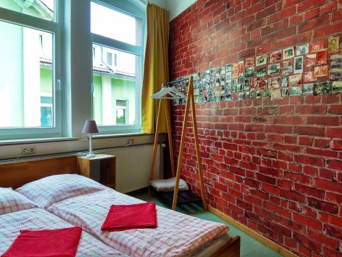 a bedroom with two beds and a brick wall at Hostel 37 in Göttingen