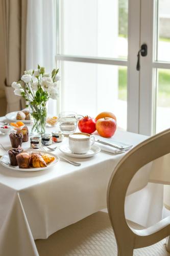 ein weißer Tisch mit Essen und Obst darauf in der Unterkunft Borgo Conde Wine Resort in Forlì