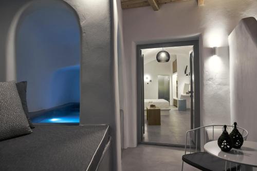 a room with a bed and a room with a mirror at Alisaris Cave Suites in Oia