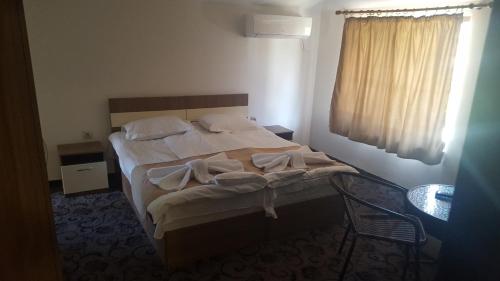 sypialnia z łóżkiem z krzesłem i oknem w obiekcie Sirakovata Kushta w mieście Saparewa Banja