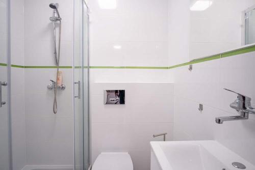 a bathroom with a shower and a toilet and a sink at Koga in Ustka