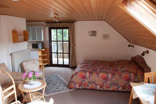 a bedroom with a bed and a table and chairs at Haus am Wald - Urlaub am Nationalpark in Langweiler