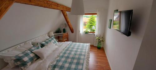 1 dormitorio con 1 cama y TV en la pared en Ferienhaus Tangrintel, en Hemau