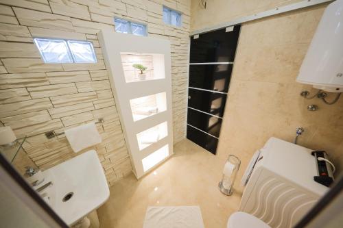 La salle de bains est pourvue de toilettes blanches et d'un lavabo. dans l'établissement Apartments Zelic, à Zadar