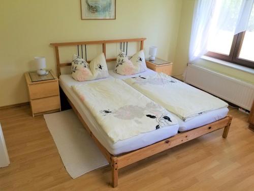 a bedroom with a wooden bed with pillows on it at Appartement am Teich in Großschönau
