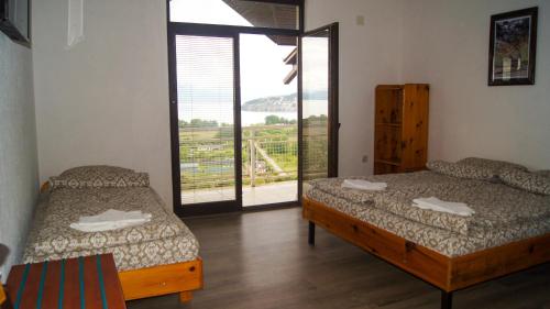 a bedroom with two beds and a balcony with a view at Villa Megdani B in Ohrid