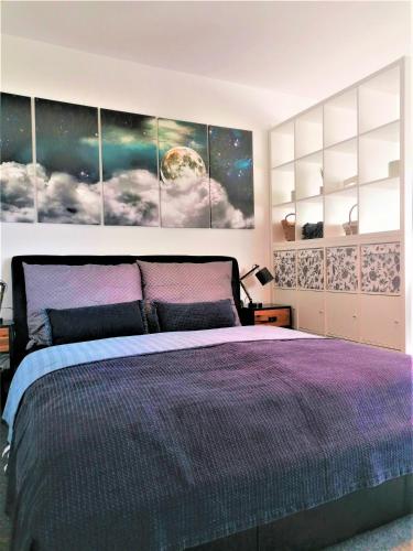 a bedroom with a bed with a large painting on the wall at Apartman 11 MyMara in Bešeňová