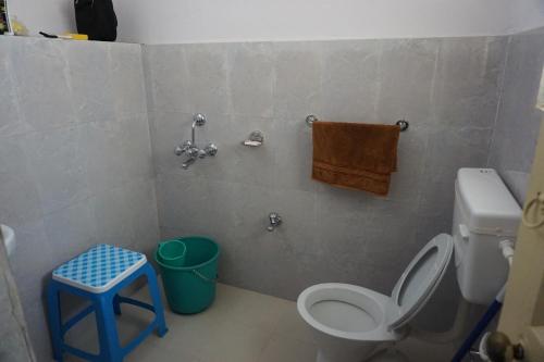 a bathroom with a toilet and a stool in it at Judges Court in Puri