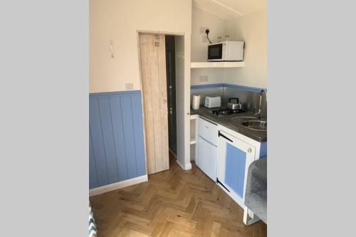 a small kitchen with a sink and a microwave at Apple Tree Hut in Tenby