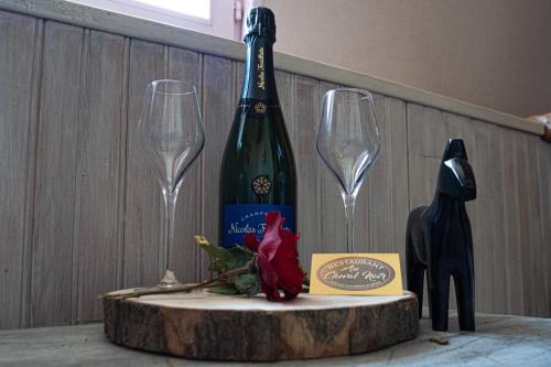 a bottle of wine and two wine glasses on a table at Au Cheval Noir in Quaëdypre