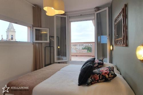 een slaapkamer met een groot bed en een groot raam bij StellaHome - Sur Les Toits in Sanary-sur-Mer