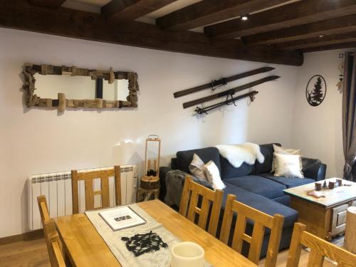 uma sala de estar com um sofá azul e uma mesa em Vall del Riu - Llar dolça llar em Soldeu