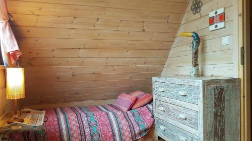 a bedroom with a bed and a dresser and a lamp at Tajgołka in Murzasichle