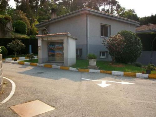 a building with an arrow painted on the side of a parking lot at Motel Cancun Barbadas-Ourense in Os Fornos