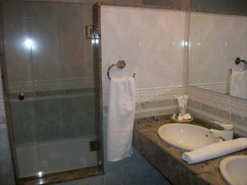 y baño con lavamanos, ducha y lavamanos. en Motel Cancun Barbadas-Ourense, en Os Fornos
