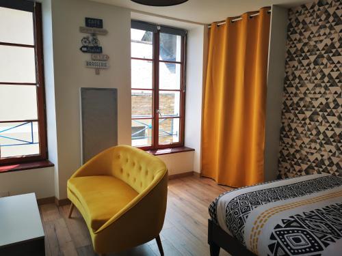 a bedroom with a yellow chair and a bed at Studio Cosy Breizh in Cancale