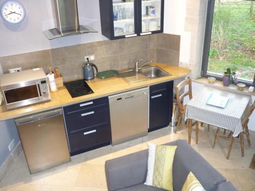a kitchen with a sink and a stove top oven at Hexagonal Tower for 2 with shared pool in Semur-en-Auxois