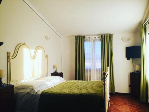 um quarto com uma cama e uma janela com cortinas verdes em B&B La Toscanina em San Miniato