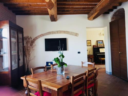 uma sala de jantar com uma mesa de madeira e cadeiras em B&B La Toscanina em San Miniato