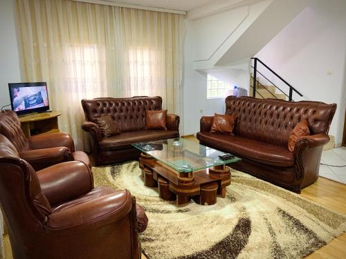 sala de estar con sofás de cuero y mesa de centro en Villa Liqenat en Peje
