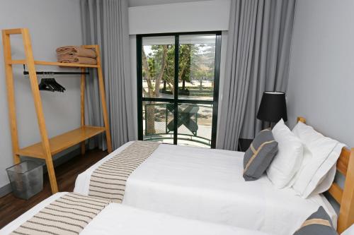 a bedroom with two beds and a window at HI Setubal - Pousada de Juventude - CASA DO LARGO in Setúbal