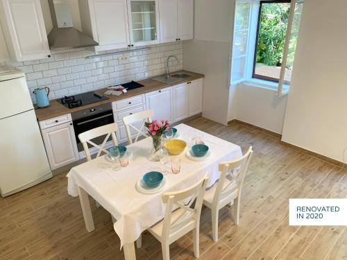 cocina con mesa blanca y sillas y cocina con mesa blanca en Stone & Salt Getaway Home, en Šimuni