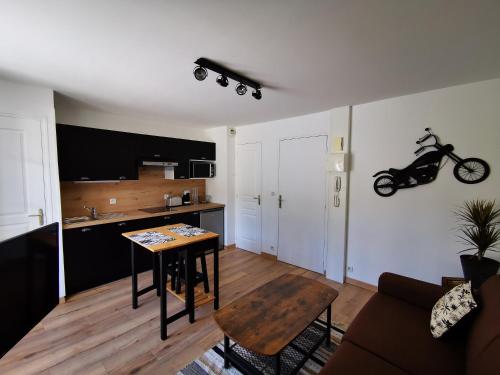 a living room with a table and a motorcycle on the wall at Studio La P'tite Escale in Cancale