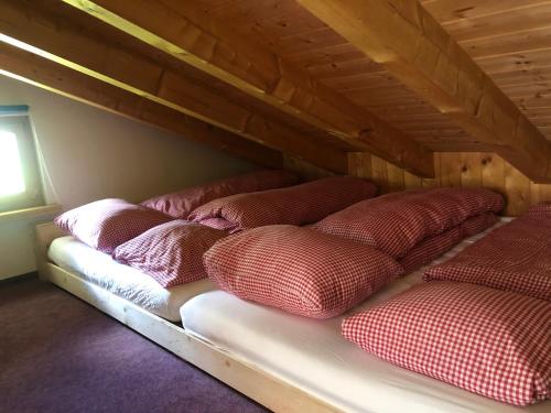 a row of pillows on a bed in a room at Casa Spel Mir in Disentis