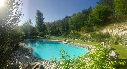 a large pool of water surrounded by trees at Borgo I Tre Baroni - Spa Suites & Resort in Poppi
