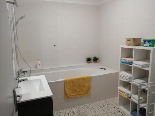 une salle de bain avec un lavabo et une baignoire dans l'établissement BEL APPARTEMENT SPACIEUX CENTRE VILLE UZES T3, à Uzès