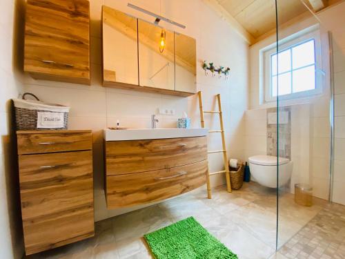 La salle de bains est pourvue d'un lavabo et d'une douche en verre. dans l'établissement Apartments Edelweiß & Enzian - Gästehaus zum Fuchs, à Hermagor