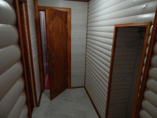 a hallway with a wooden door and a walk in closet at Відпочинок у Євгена та Оксани in Yaremche
