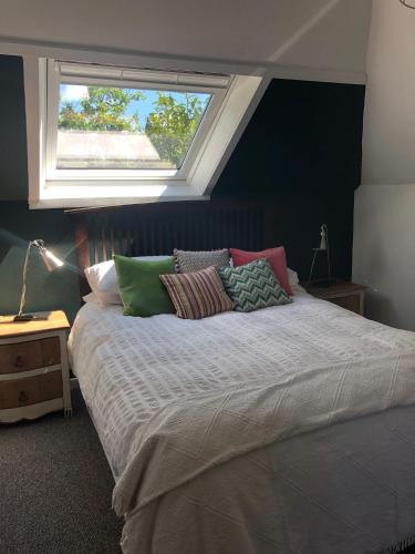 a bedroom with a large bed with a window at Fox Cottage in Moffat