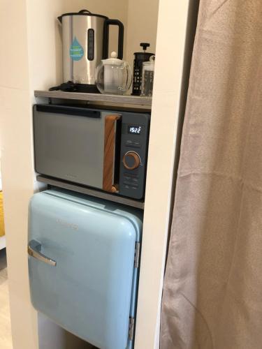 a small refrigerator with a microwave on top of it at Escale beauté le Crotoy in Le Crotoy