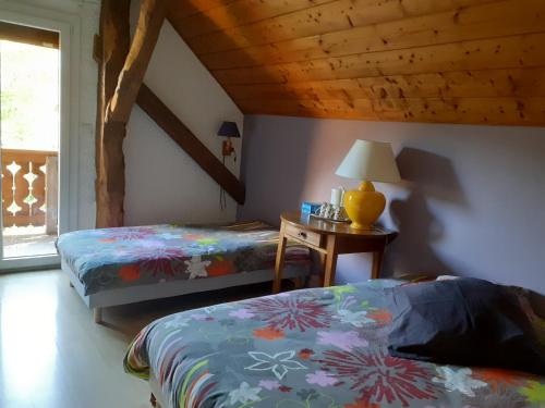 ユジーヌにあるChez Marieのベッドルーム1室(ベッド2台、ランプ付きテーブル付)