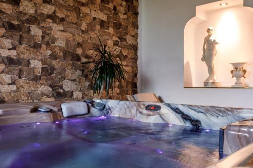 een hot tub in een kamer met een stenen muur bij Sherwood Hotel Vojkovice nad Ohří in Vojkovice